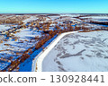 Aerial view of a frozen lake and dam on a sunny winter day 130928441
