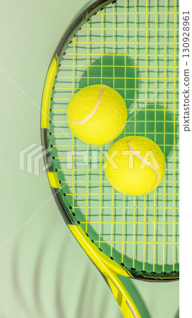Tennis banner. Sport composition with yellow tennis balls and rackets on a green background with copy space Tennis banner. Sport composition with yellow tennis balls and rackets on a green background with copy space 130928961