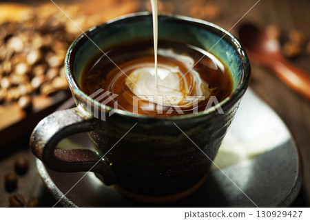 Fresh cream poured into coffee 130929427