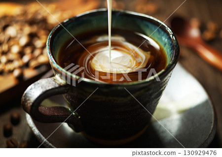 Fresh cream poured into coffee Fresh cream poured into coffee 130929476