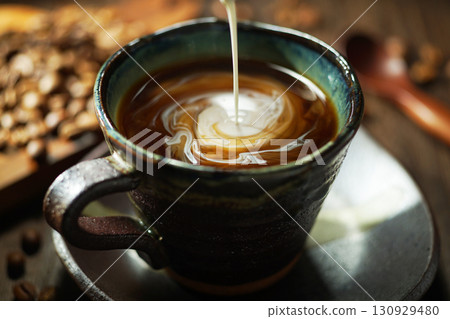 Fresh cream poured into coffee 130929480