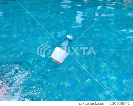 Plastic bottle floating on clear blue water, symbolizing pollution and environmental issues in aquatic environments. Plastic bottle floating on clear blue water, symbolizing pollution and environmental issues in aquatic environments. 130930641