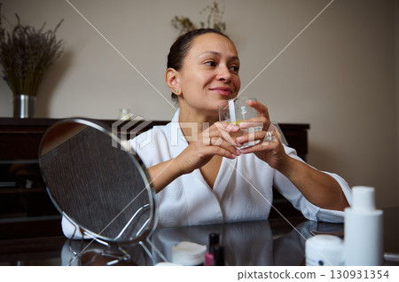 Elegant Woman Enjoying a Refreshing Beverage in a Calm Setting Elegant Woman Enjoying a Refreshing Beverage in a Calm Setting 130931354