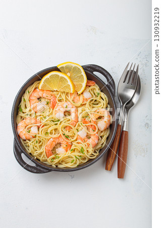 Delicious seafood pasta spaghetti with shrimps dish garnished with lemon and parsley top view on white background Delicious seafood pasta spaghetti with shrimps dish garnished with lemon and parsley top view on white background 130932219