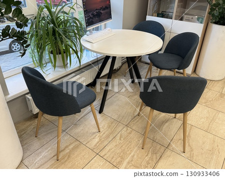 Meeting area in the company's office round white table and chairs. High quality photo Meeting area in the company's office round white table and chairs. High quality photo 130933406