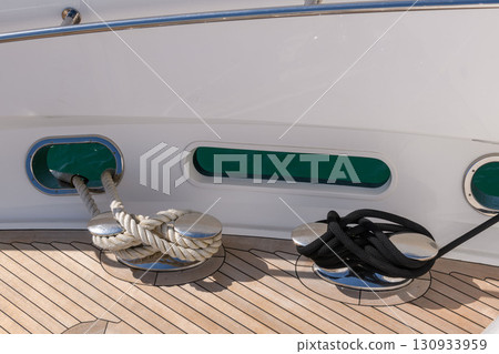 Bollard (cleat) with mooring line on superyacht. Mooring gear on yacht. Superyacht equipment. Side view. 130933959