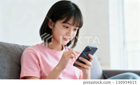 看著智慧型手機的微笑的年輕女孩 130934015