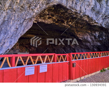 Cave prayer room featuring a serene altar in a natural setting with bright red accents Cave prayer room featuring a serene altar in a natural setting with bright red accents 130934391