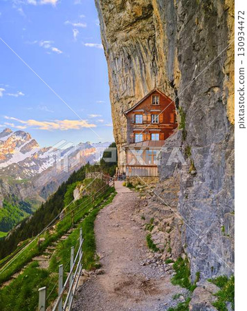 Lodging nestled against a mountain cliff with panoramic views of the Swiss Alps 130934472