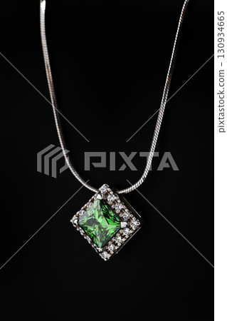 A green gemstone pendant is displayed on a black background 130934665