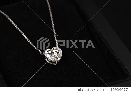 A heart shaped pendant with a chain is displayed in a black box 130934677