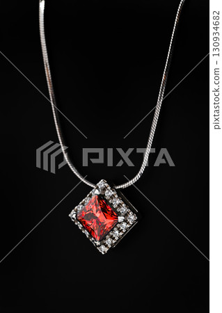 A white gold necklace with a red gemstone pendant A white gold necklace with a red gemstone pendant 130934682