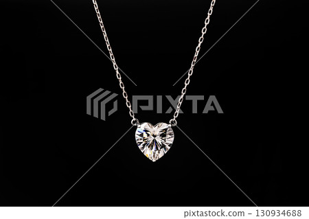 A necklace with a heart pendant is on a black record A necklace with a heart pendant is on a black record 130934688