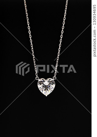 A heart shaped pendant with a chain is displayed in a black box 130934695