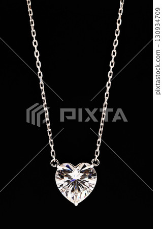 A heart shaped pendant with a chain is displayed in a black box 130934709