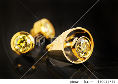 A gold ring with a yellow stone in the center A gold ring with a yellow stone in the center 130934715