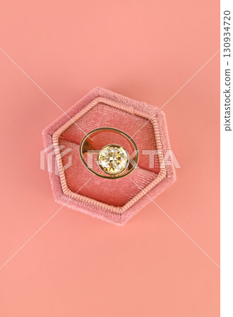A ring is in a pink velvet box 130934720