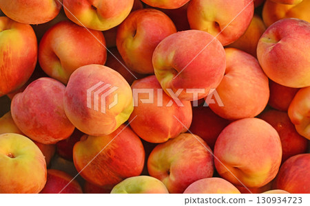 A bunch of peaches are piled on top of each other A bunch of peaches are piled on top of each other 130934723