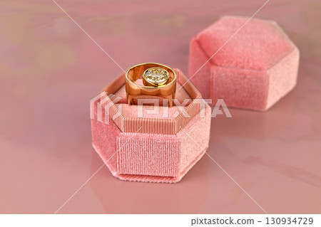 A ring is in a pink velvet box 130934729