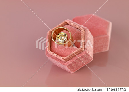 A ring is in a pink velvet box 130934730