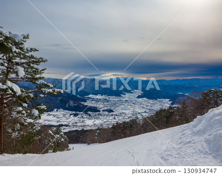 從雲霧繚繞的滑雪場眺望雪山與山麓的全景（長野縣山之內町夜瀨） 130934747