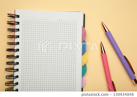 Notebook with colorful pens on beige background. 130934848