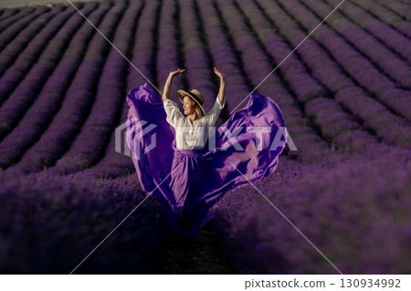 A woman in a purple skirt is dancing in a field of lavender 130934992