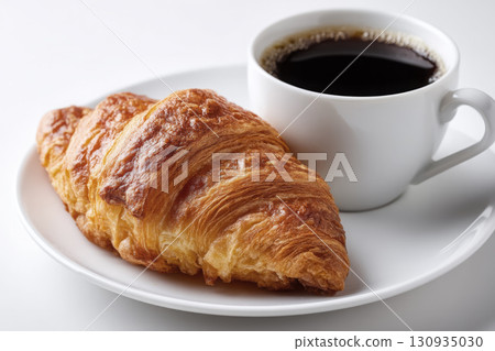 A steaming cup of coffee next to a butter croissant A steaming cup of coffee next to a butter croissant 130935030