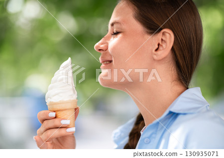 Icecream Woman Summer: Woman enjoys sweet dessert outdoors on sunny day to stay cool. 130935071