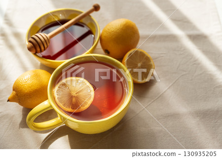Flat Lay with Lemon Tea and Honey on Light Table under Sun Light 130935205