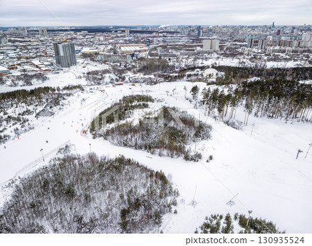 Aerial View of Ski slopes on Mount Uktus, Yekaterinburg, Ural, Russia. Aerial View of the Ski Resort in Mountains at Winter. Aerial view of ski elevator. 130935524