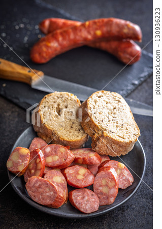 Sliced smoked sausage on plate. 130936223