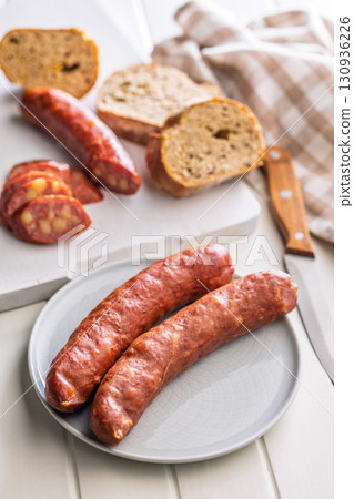 Sliced smoked sausage on plate. 130936226