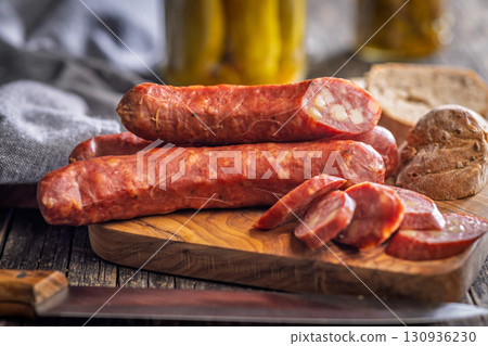Sliced smoked sausage on cutting board. 130936230