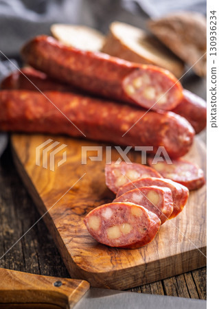 Sliced smoked sausage on cutting board. Sliced smoked sausage on cutting board. 130936234