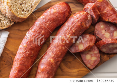 Sliced smoked sausage on cutting board. 130936239