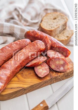 Sliced smoked sausage on cutting board. 130936240