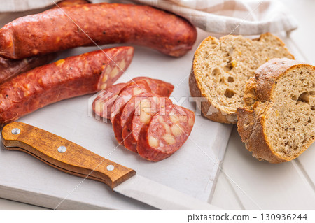 Sliced smoked sausage on cutting board. Sliced smoked sausage on cutting board. 130936244