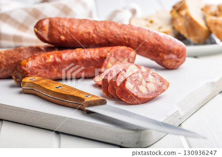 Sliced smoked sausage on cutting board. 130936247