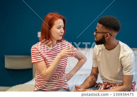 Young interracial couple husband and wife sit on bed at home discussing intimacy issues Young interracial couple husband and wife sit on bed at home discussing intimacy issues 130936475
