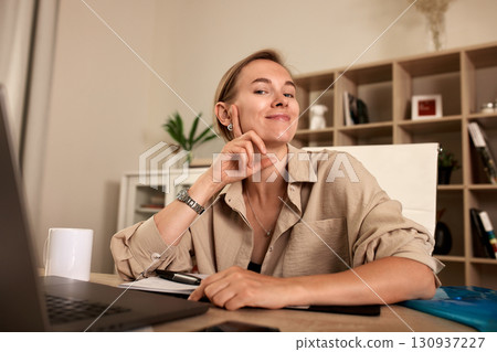 Confident Woman Working at Desk in Modern Office Atmosphere 130937227