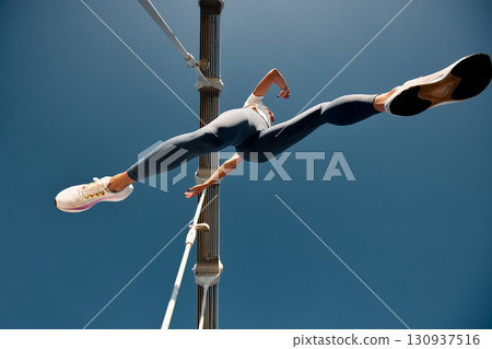 Dynamic low-angle shot of an athletic individual in focused running motion 130937516