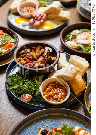 Traditional English breakfast with baked beans, bread, vegetables and grilled vegetables 130937876