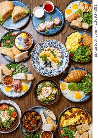 Assorted gourmet breakfast dishes on a rustic wooden table, top view 130937881
