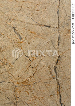 Natural stone surface with warm tones and intricate patterns found in a rocky environment 130938114