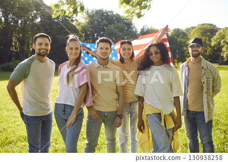 International friends posing together in park holding USA flag celebrating america Independence day International friends posing together in park holding USA flag celebrating america Independence day 130938258