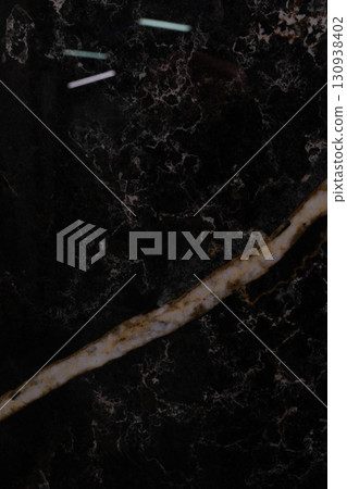 Dark marble surface with contrasting light veins and textured patterns for elegant interior design Dark marble surface with contrasting light veins and textured patterns for elegant interior design 130938402