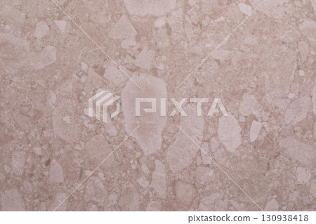 Natural stone surface with unique textures and patterns showcasing elegant light beige tones and 130938418