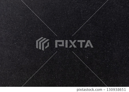 Black textured surface with fine particles in a dark setting, suitable for various applications or 130938651