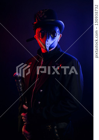 Steampunk plague doctor costume for Halloween. Plague doctor with crow-like mask on black background Steampunk plague doctor costume for Halloween. Plague doctor with crow-like mask on black background 130938732